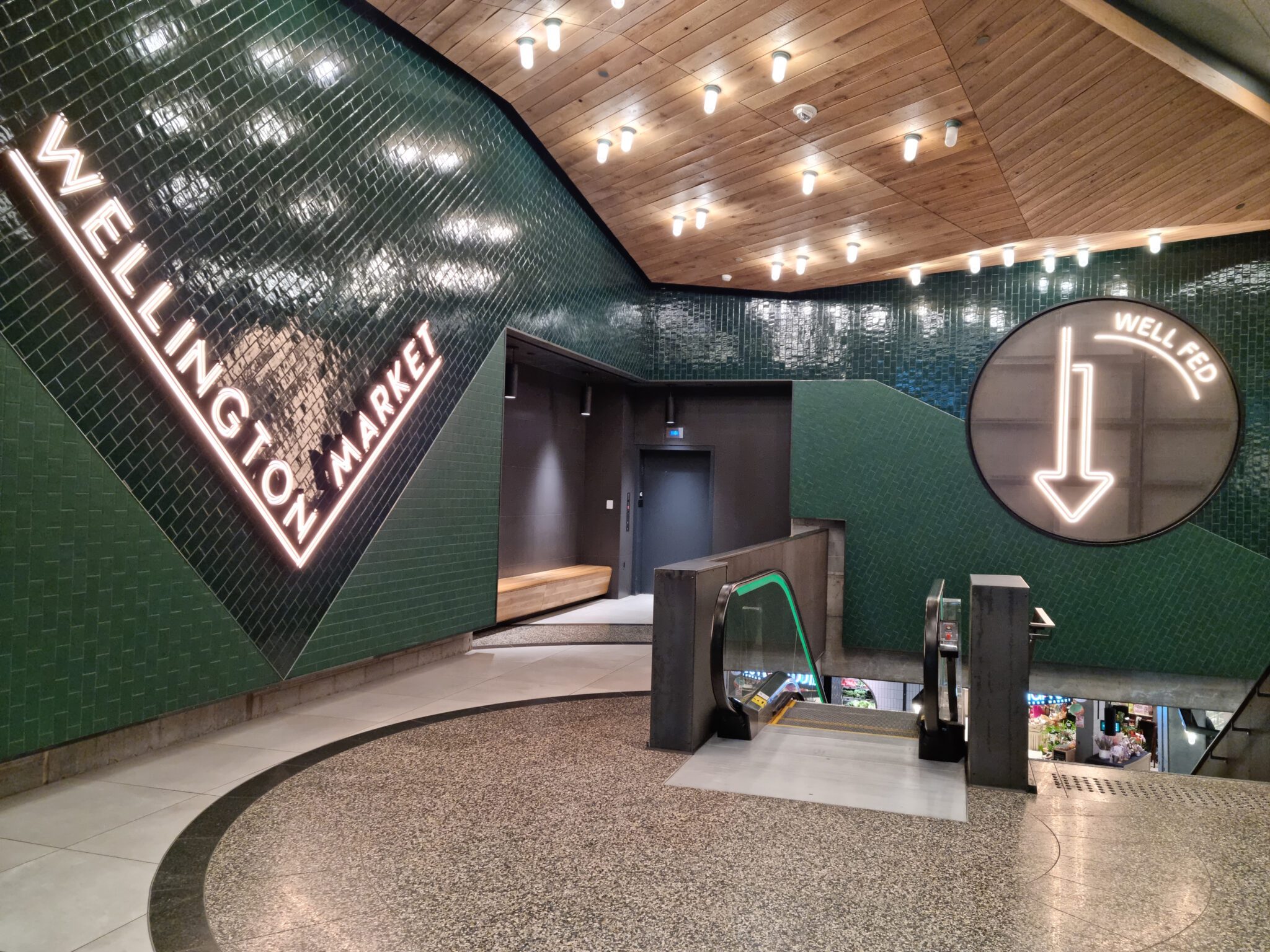 Wellington Market entry with signage, green tile walls, and wood ceiling